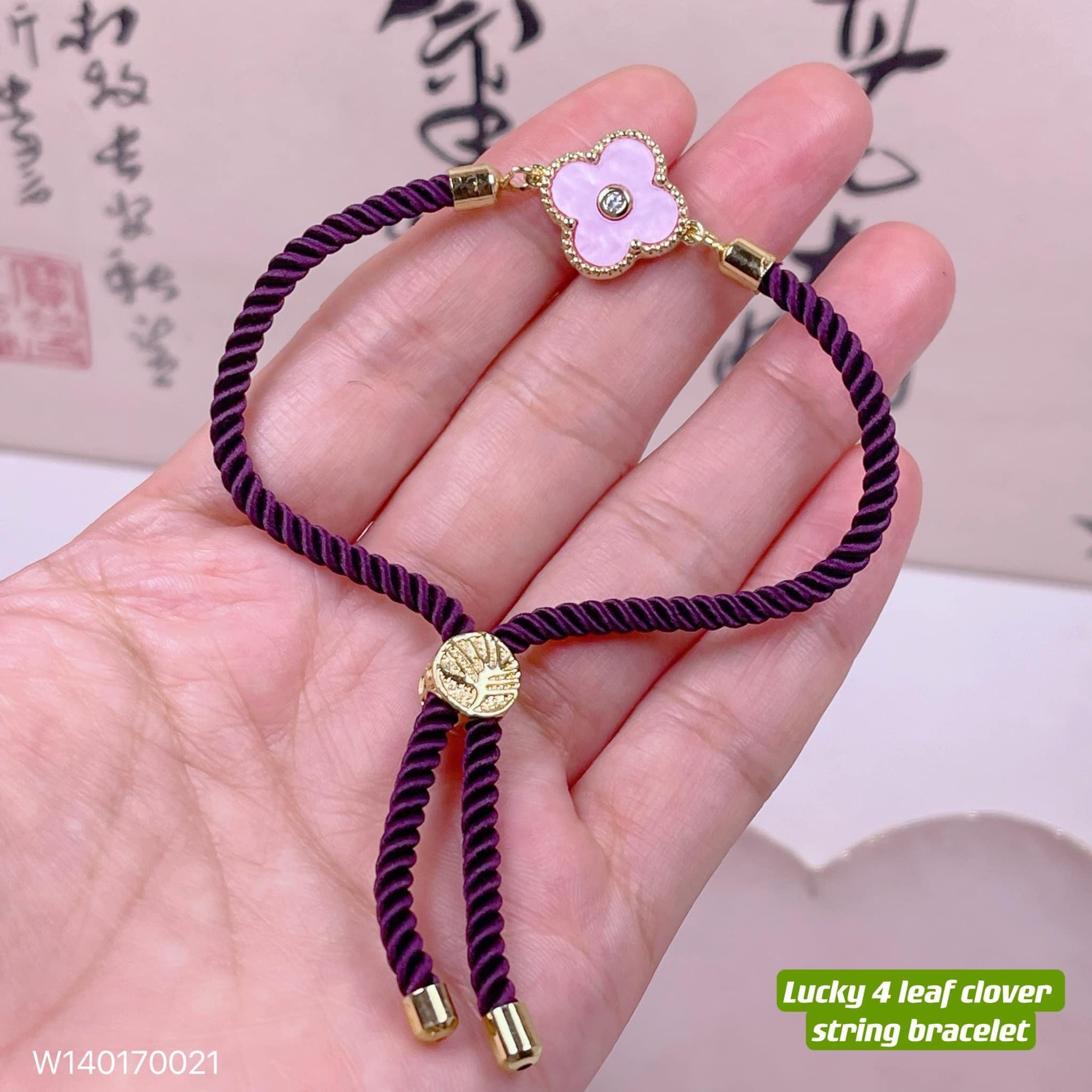 A bracelet on a thong with a four-leaf clover –